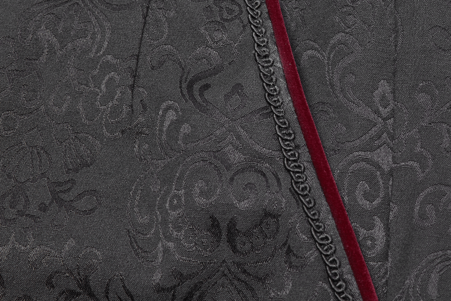 Close-up of Gothic Jacquard fabric with ornate patterns and velvet trim, showcasing luxurious textures and dark elegance.