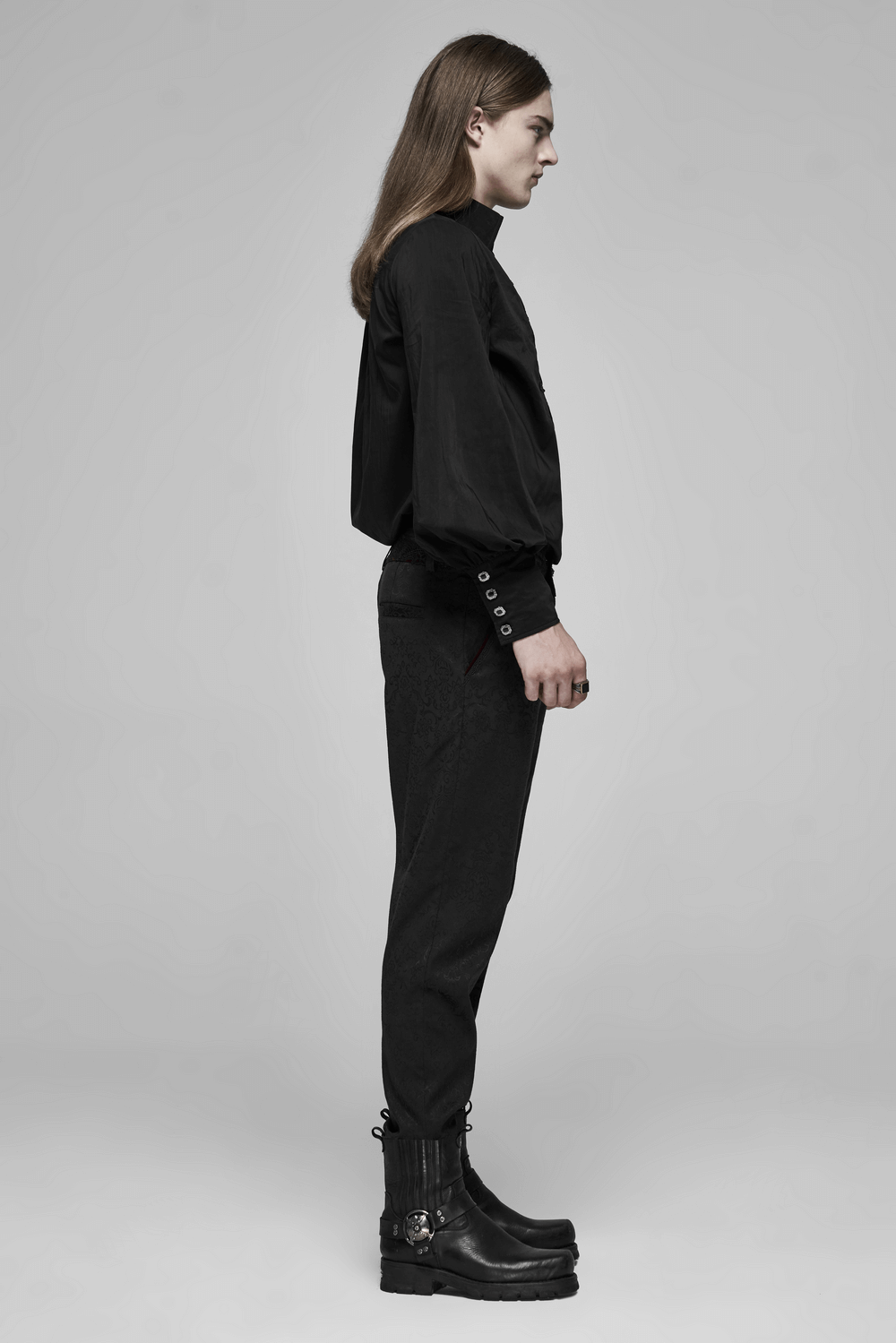 Side view of a model in black Gothic Jacquard lace pants with metal buttons, showcasing a dark romantic style.