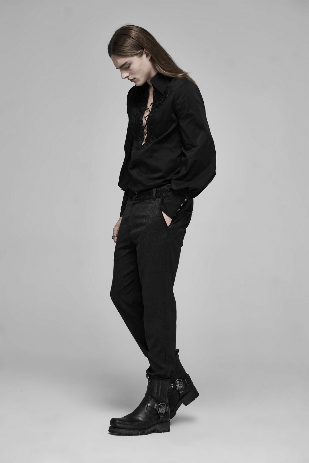 Stylish model in a black outfit featuring gothic lace details and rugged boots, showcasing a dark romantic aesthetic.