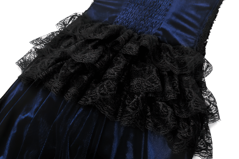 Close-up of gothic corset dress with intricate black lace ruffles and luxurious blue velvet fabric.