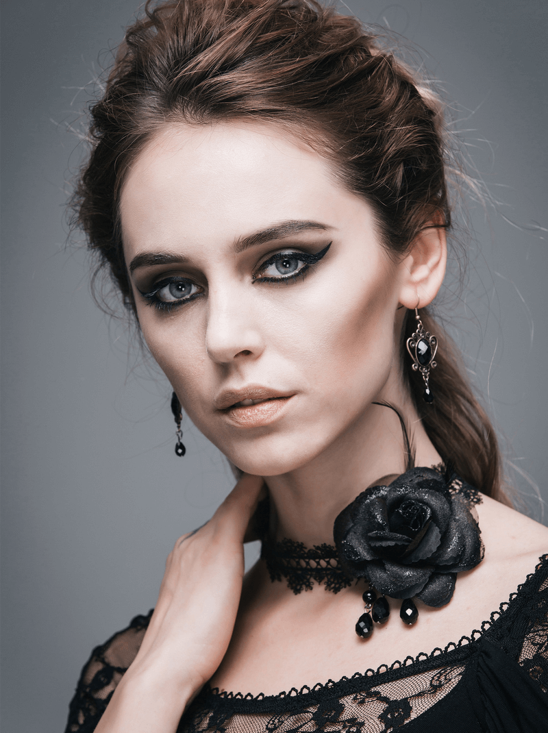 Stylish model wearing a gothic black lace choker with a rose and matching earrings for a vintage look.