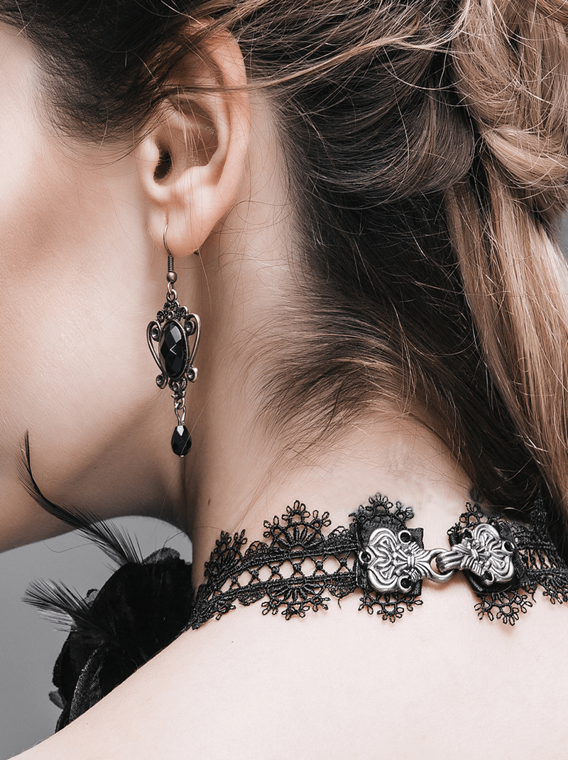 Close-up of a woman's neck showcasing a gothic lace choker and matching earring with intricate design.
