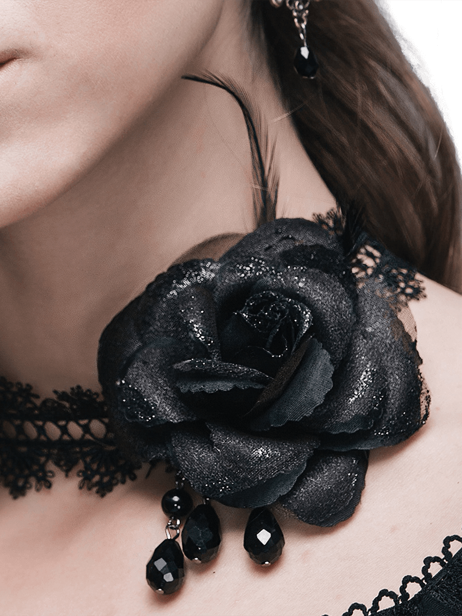 Gothic black lace choker with a rose accent and dangling beads, perfect for vintage fashion lovers.