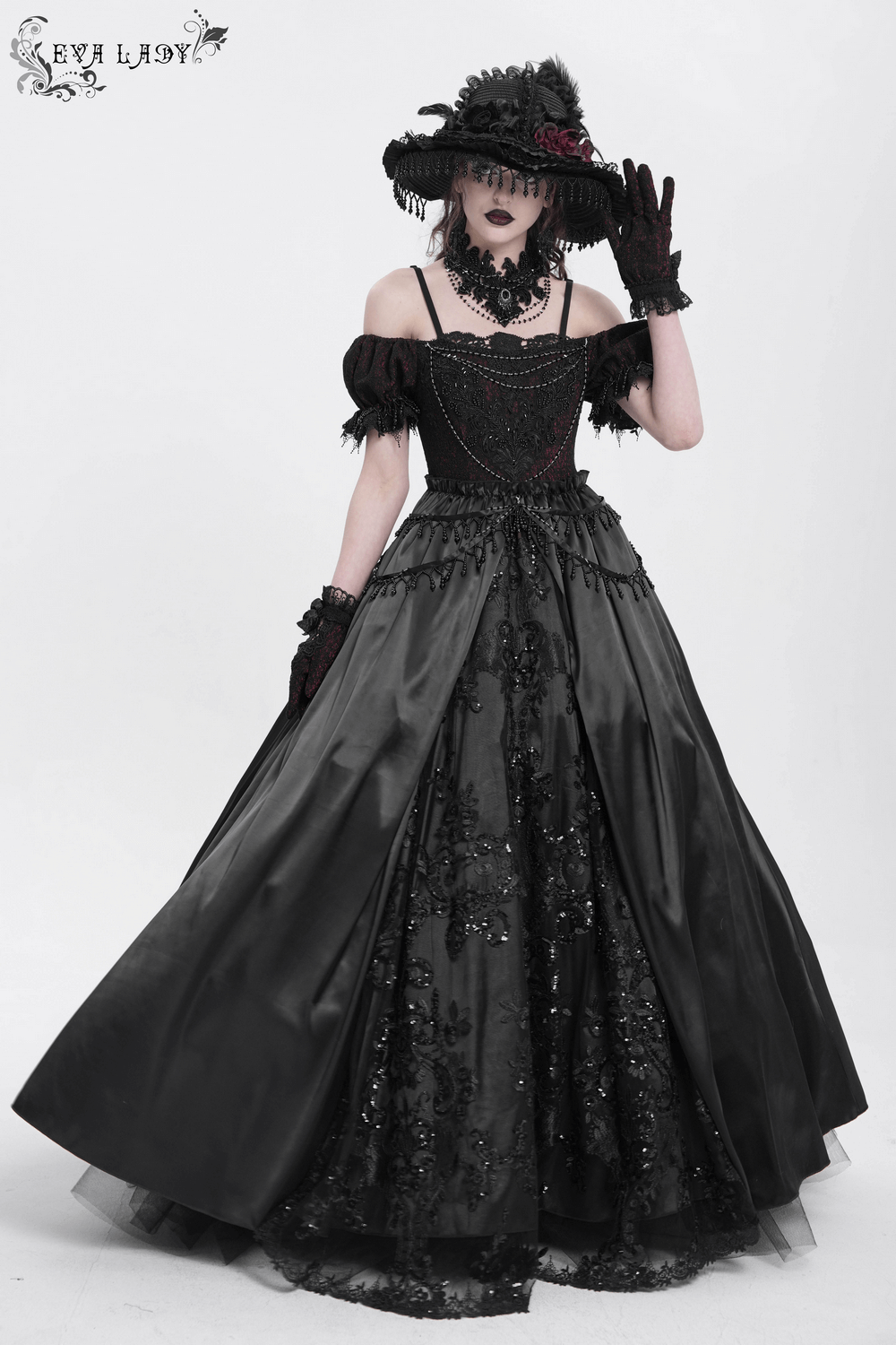 Gothic lace-back maxi dress with chain detail, styled with gloves and a large hat, perfect for dramatic occasions.