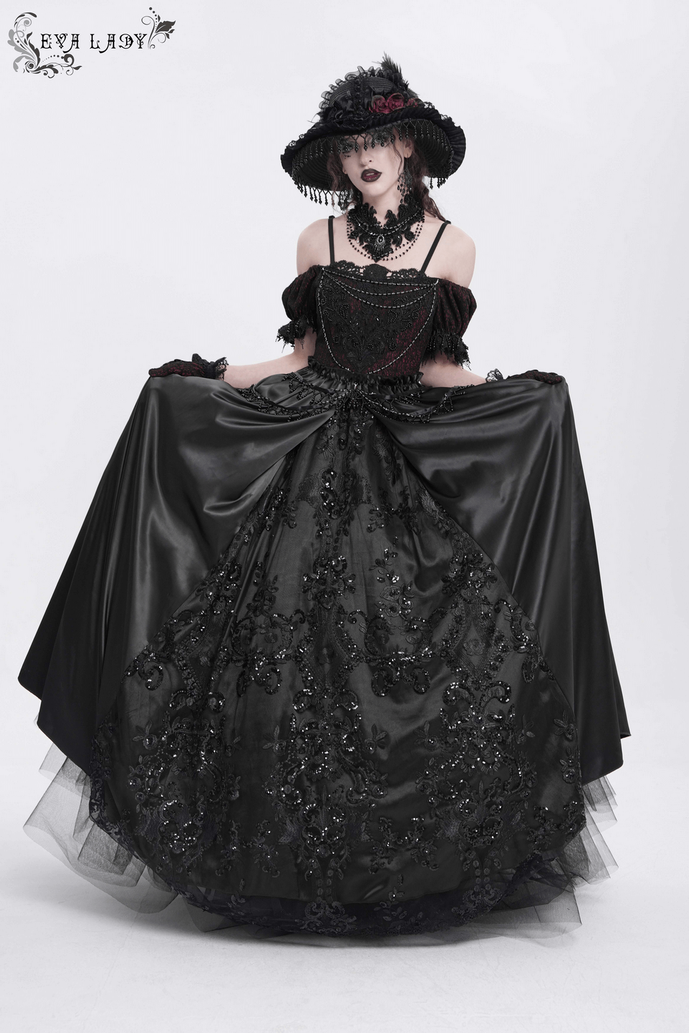 Gothic lace-back maxi dress with chain detail, worn by model, showcasing intricate design and detailed lacing.