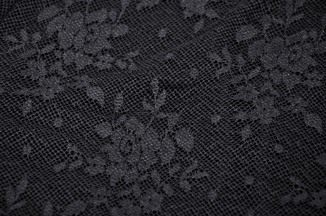 Close-up of elegant black lace fabric with floral patterns for Gothic fashion.