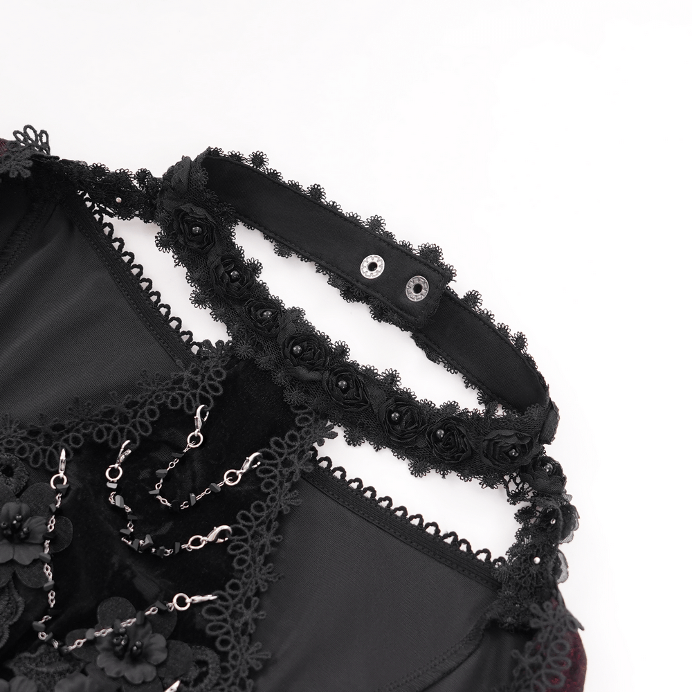 Close-up of black lace top with rose embellishments and flared sleeves, showcasing gothic elegance.