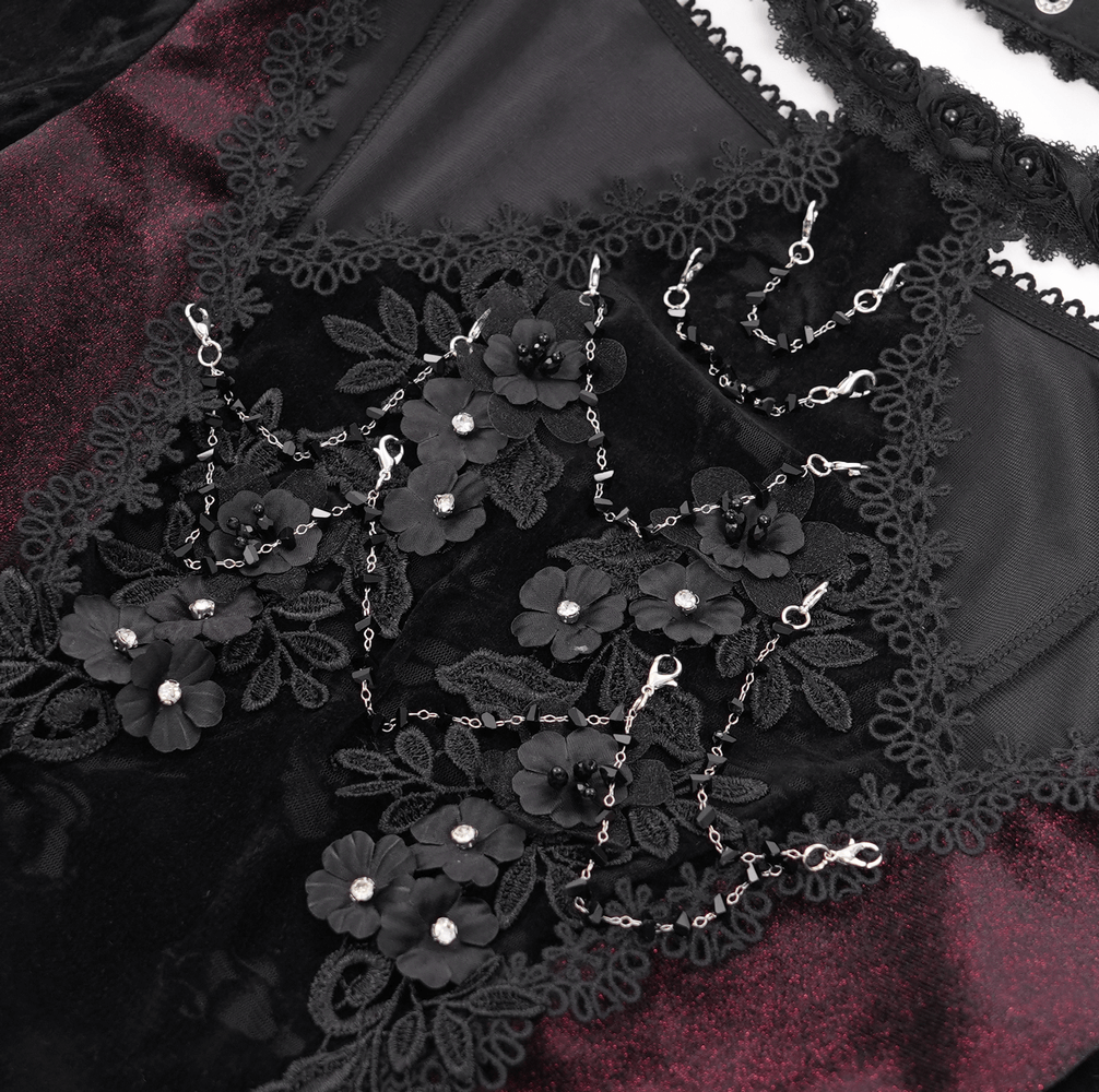 Close-up of gothic lace top featuring black floral embellishments and intricate lace detailing.