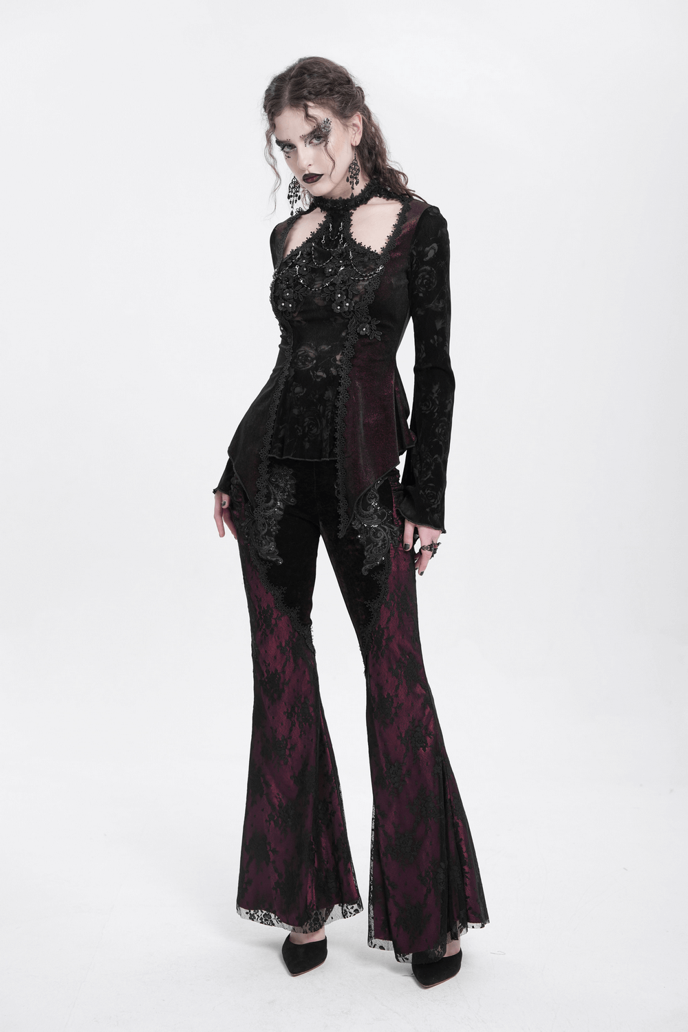 Gothic lace top with flared sleeves and rose embellishments, paired with dark flared pants, exuding Victorian elegance.