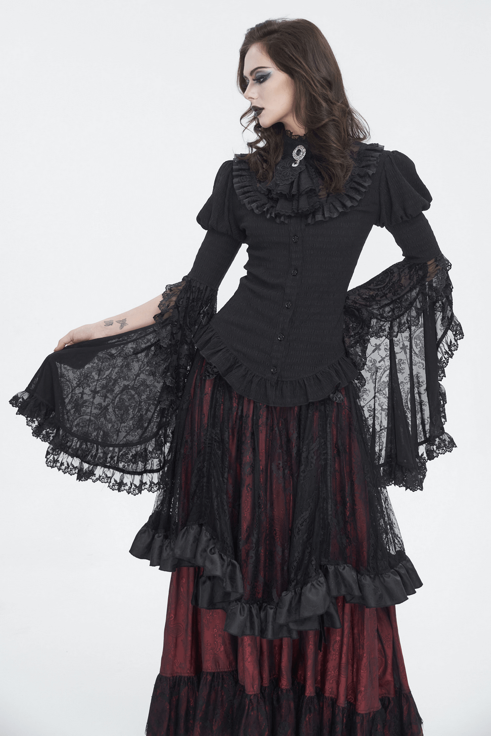Gothic lace blouse with ruffled neck and flared sleeves paired with a long, romantic skirt in a dramatic black and red ensemble.