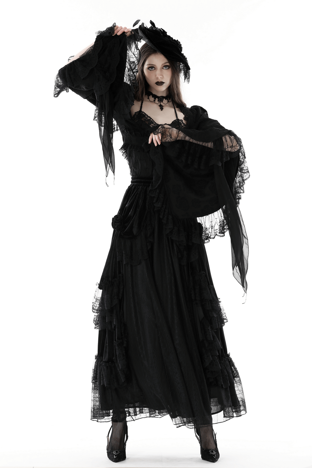 Elegant model in black gothic dress with bell sleeves and ruffles, showcasing evening elegance and dramatic flair.
