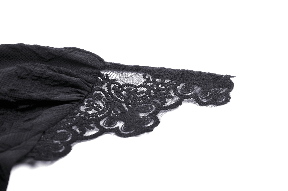 Close-up of intricate black lace detailing on a gothic crop top, showcasing elegant texture and design.