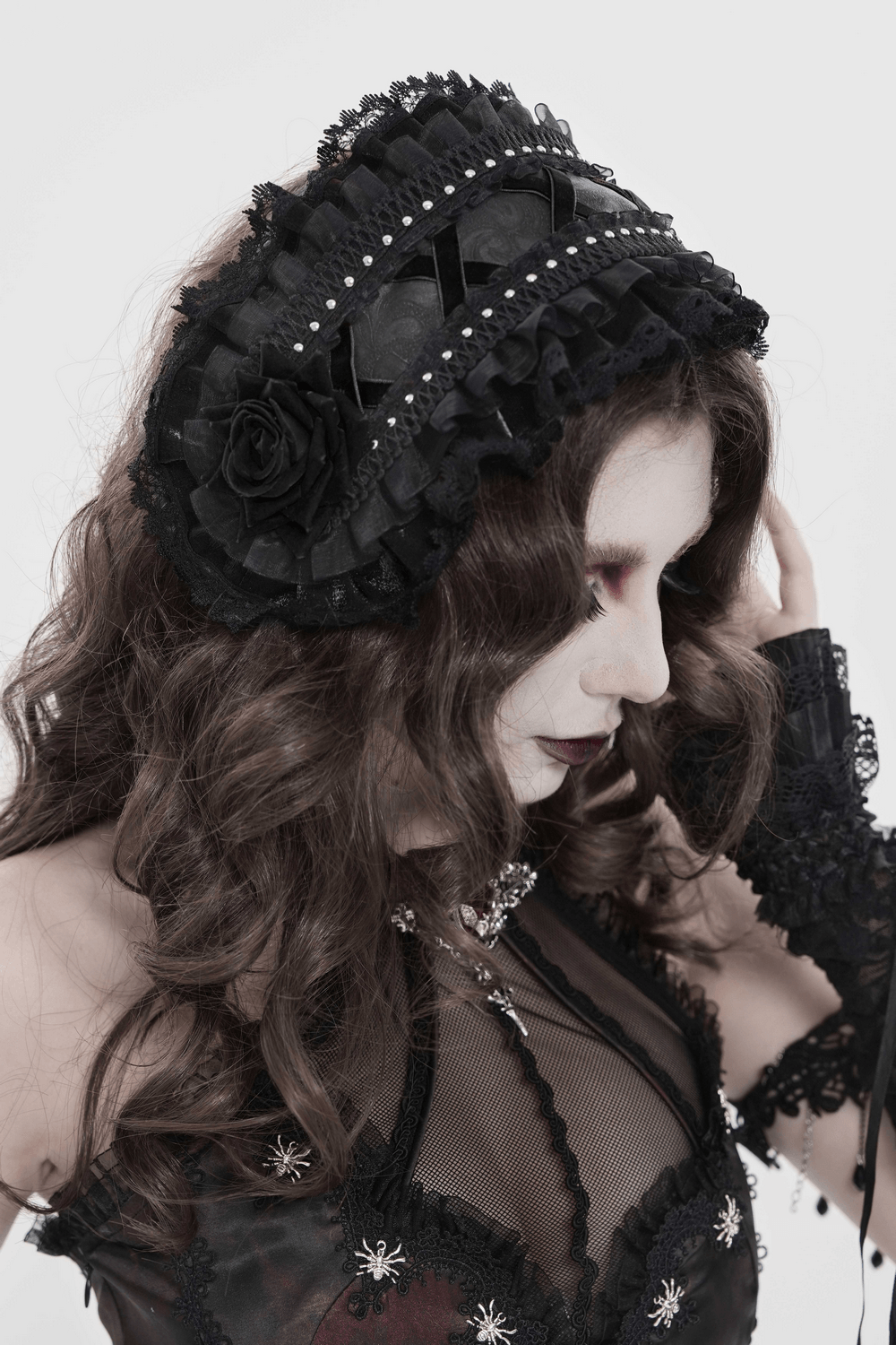Gothic Lace Bonnet Headpiece with Rose Details worn elegantly by a model, showcasing intricate lace and flower accents.