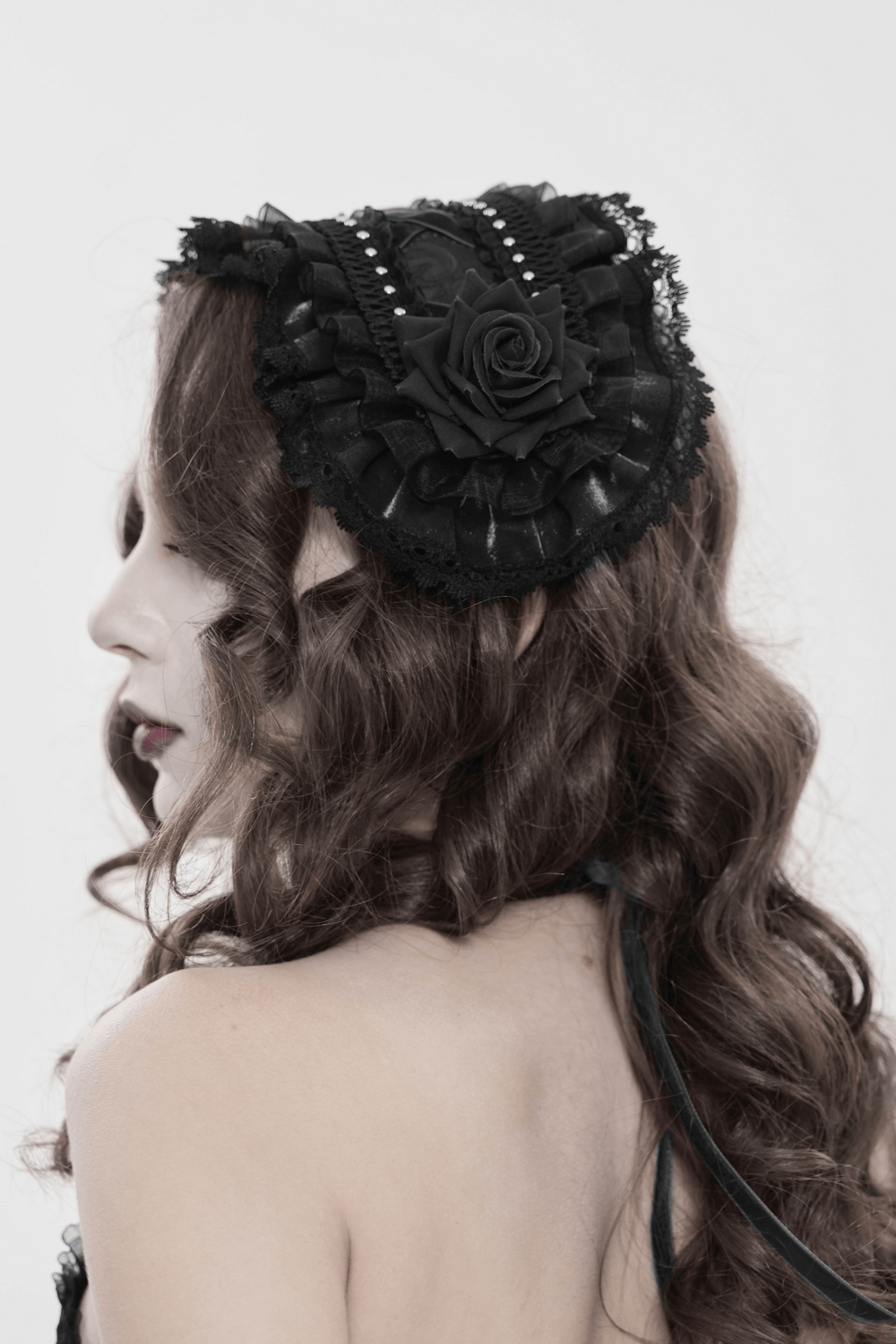 Gothic Lace Bonnet Headpiece with Rose Details elegantly displayed on model's head, showcasing intricate lace and rose design.