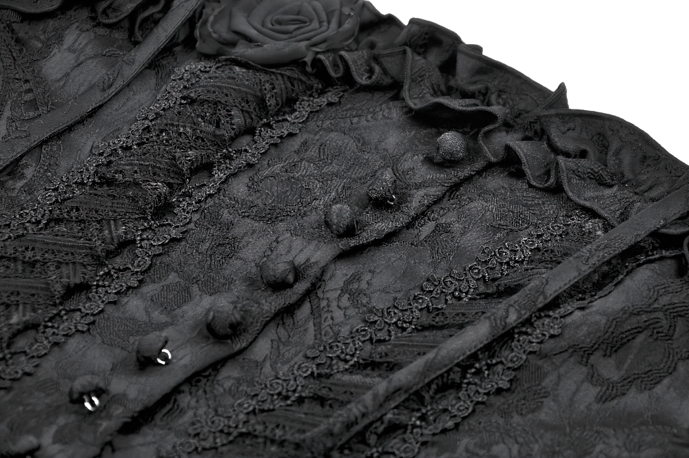 Close-up of a gothic lace corset top featuring intricate brocade, decorative buttons, and ruffled trim in black.
