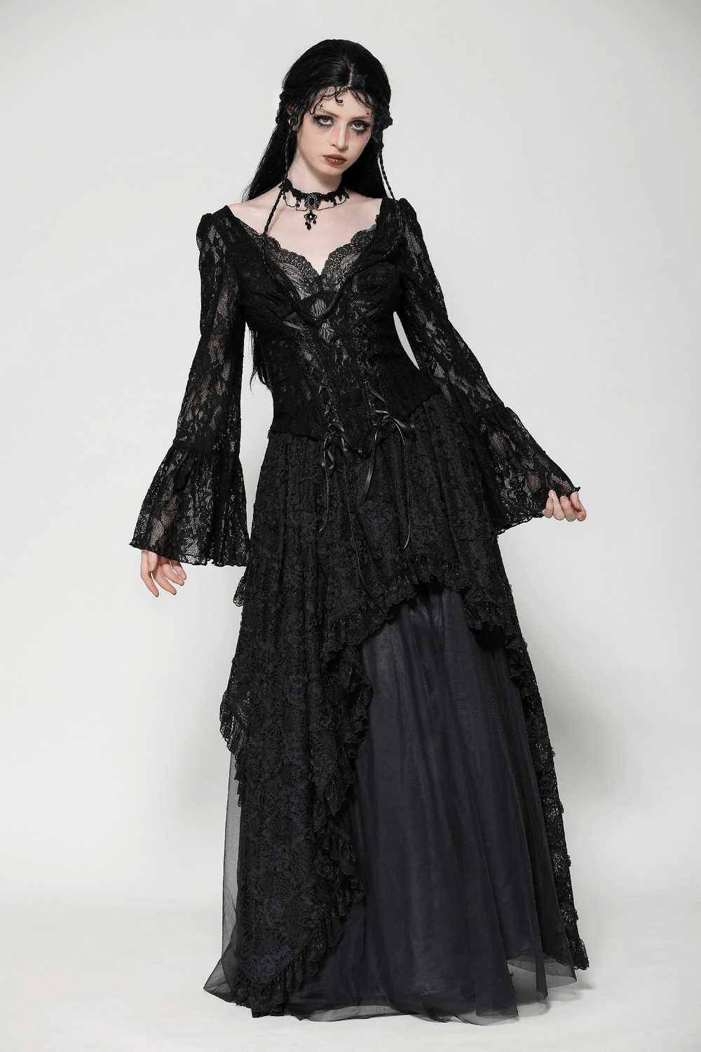 Victorian-inspired black lace gothic corset top with bell sleeves and tie accents styled with a flowing black skirt.