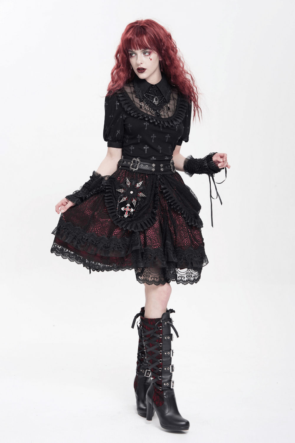 Model wearing a gothic outfit with a layered lace skirt and lace-trimmed blouse, styled with knee-high boots.