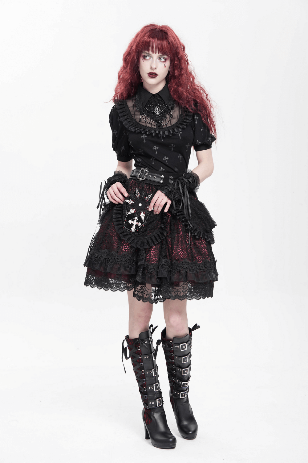Model showcasing a gothic outfit with a black lace top, layered skirt, and tall buckled boots for a dramatic look.