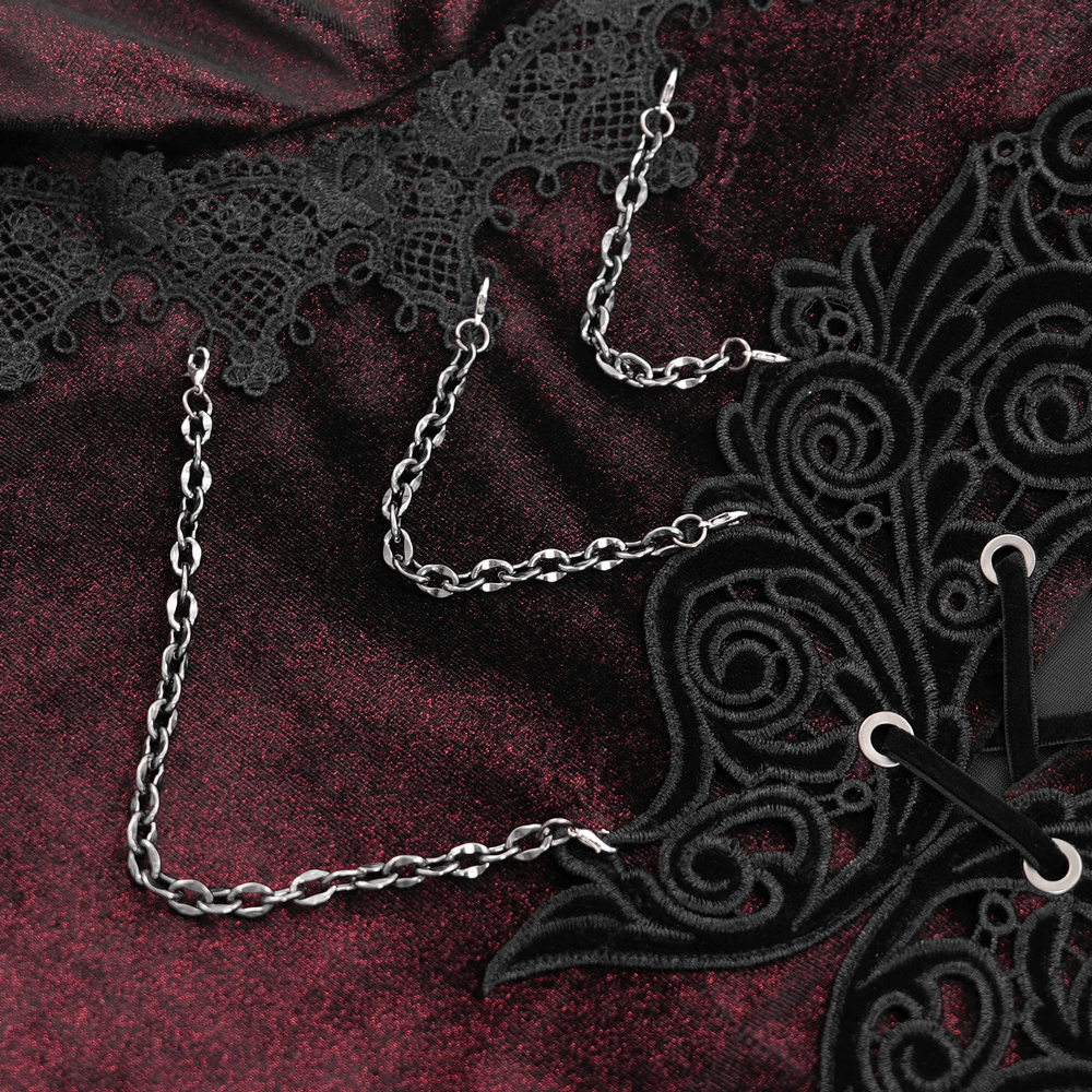 Close-up of gothic lace detailing and chains on a rich dark velvet shirt, showcasing Victorian elegance and macabre style.