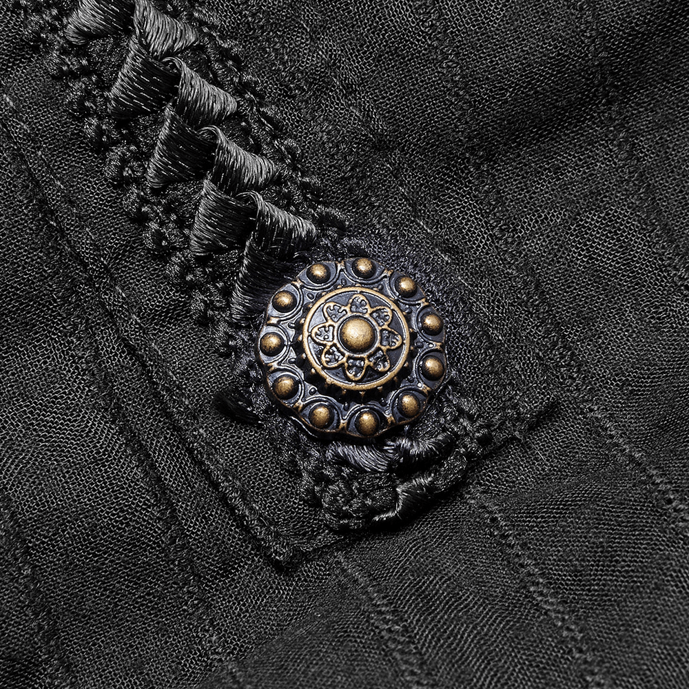 Close-up of a decorative vintage button on a gothic black dress with intricate lace details.