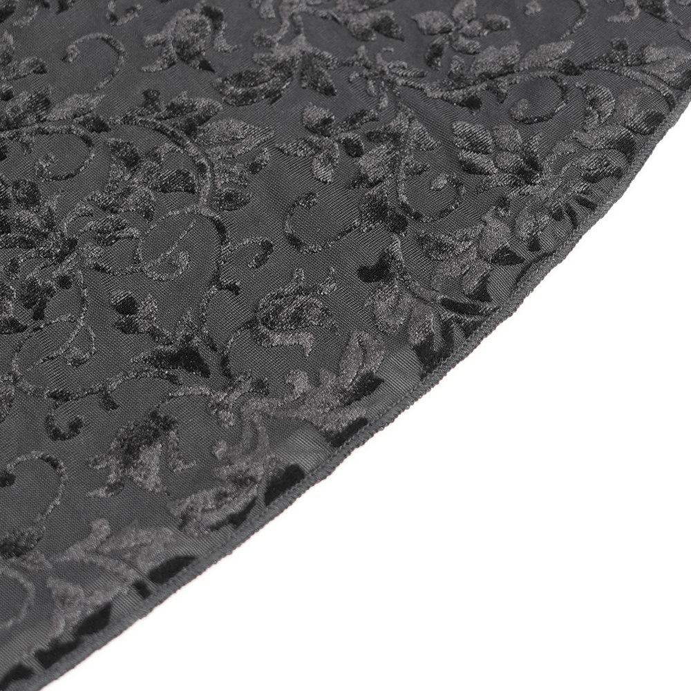 Close-up of luxurious black velvet fabric with intricate floral lace detailing for gothic fashion.