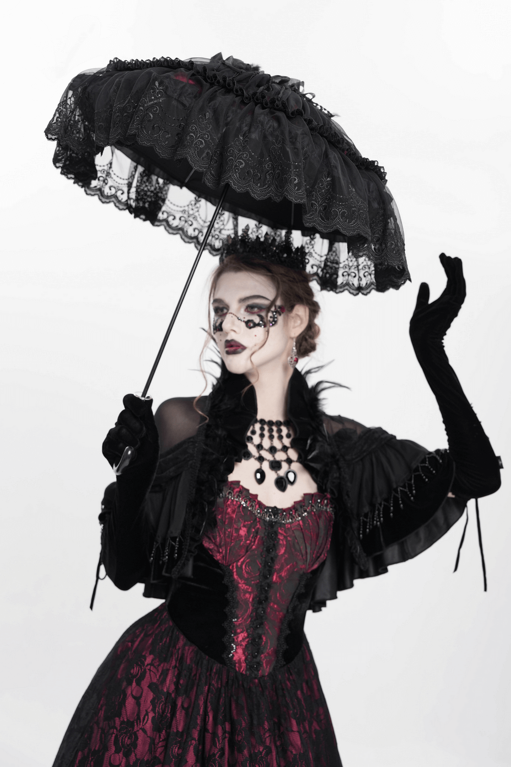Gothic lace fringe umbrella with roses held by a model in a dramatic vintage-inspired outfit.