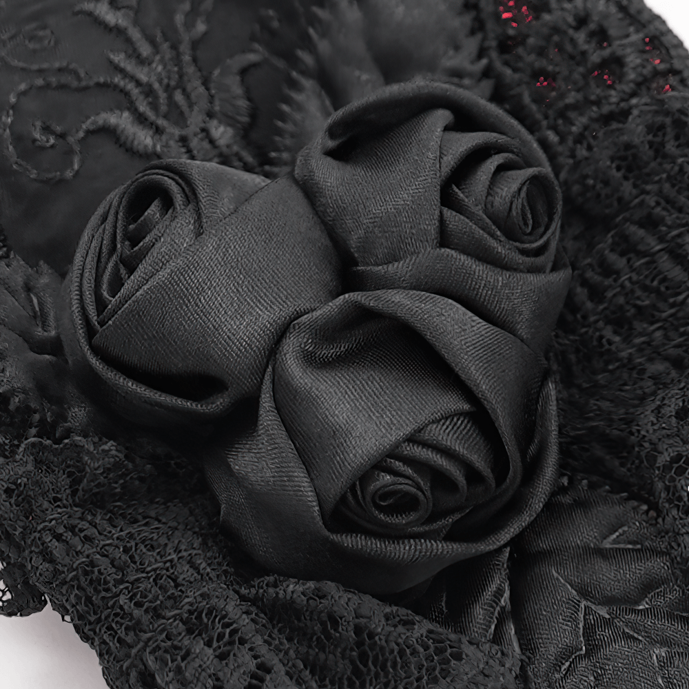 Close-up of elegant black satin roses on gothic lace gloves, showcasing intricate details and vintage charm.