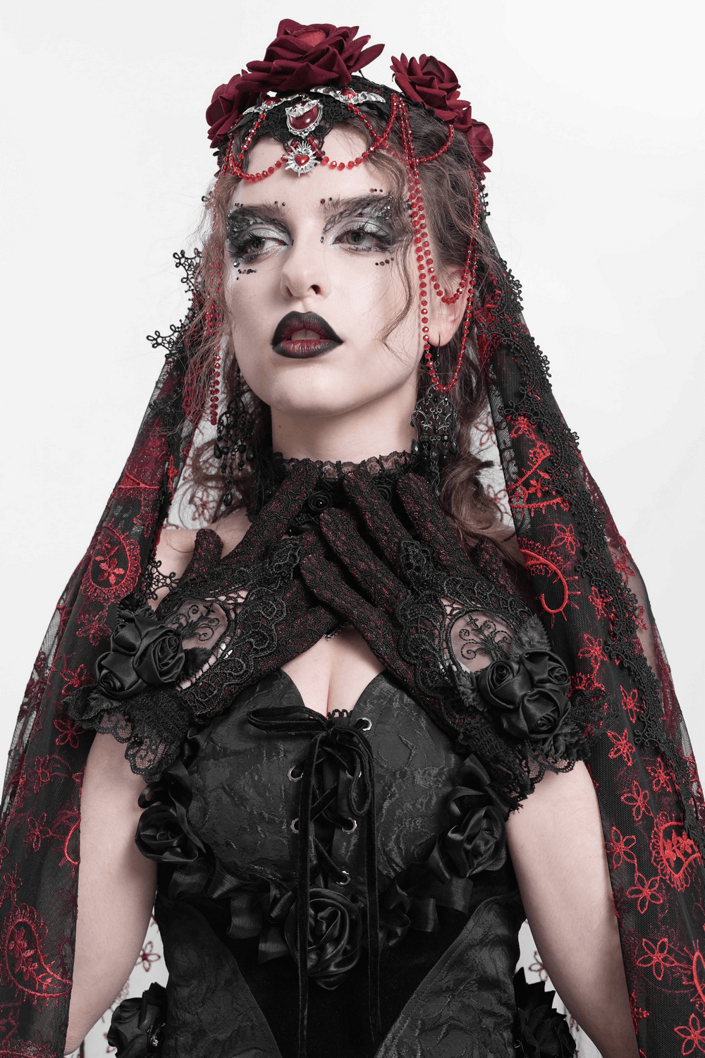 Gothic model wearing red and black lace gloves, adorned with roses and mesh, showcasing Victorian style elegance.