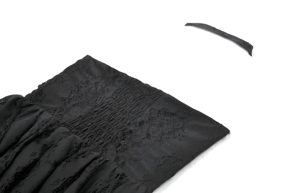 Close-up of the textured black fabric and lace trim of a gothic halter dress with keyhole neckline.