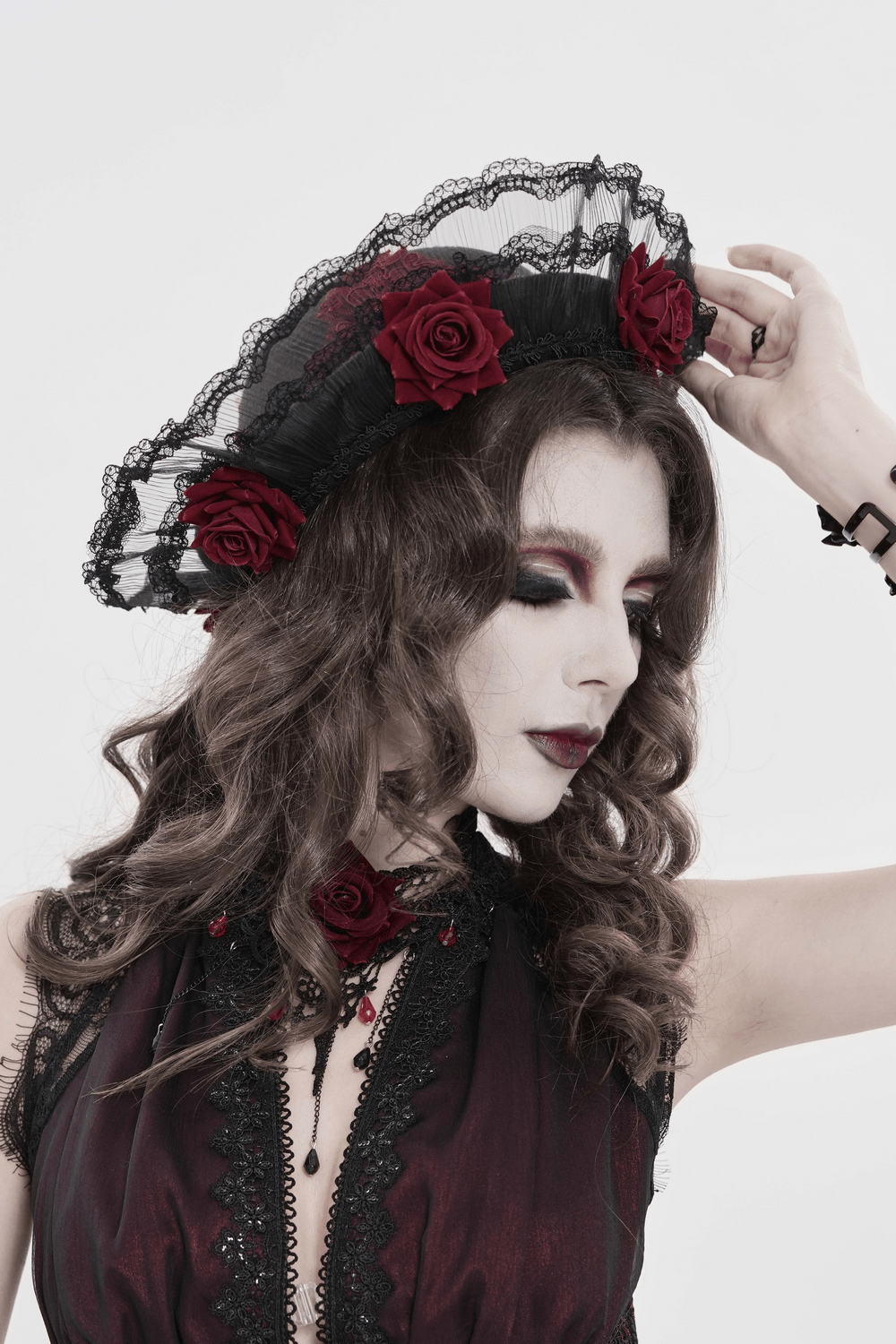 Gothic Lace Hat with Burgundy Roses and Veil Trim worn by model featuring black lace and red roses.