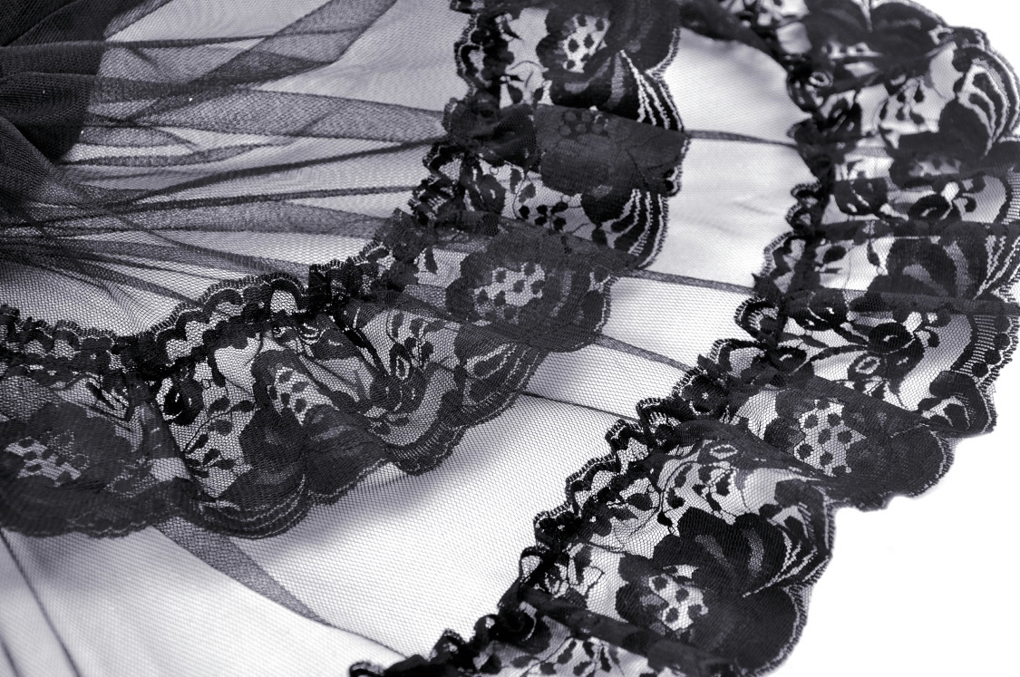 Close-up of black lace fabric showcasing intricate floral patterns and delicate mesh for gothic fashion.