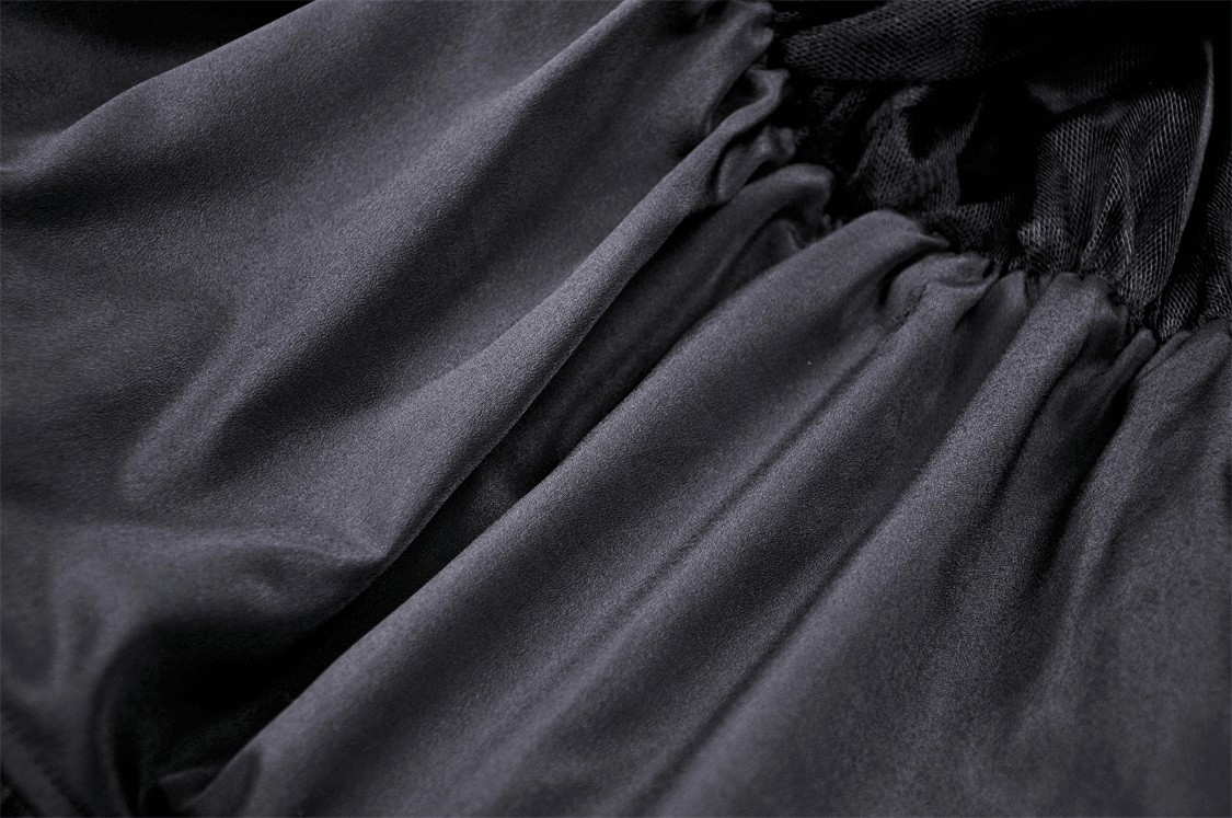 Close-up view of luxurious black fabric showcasing the soft, flowing texture of a gothic hi-low skirt.