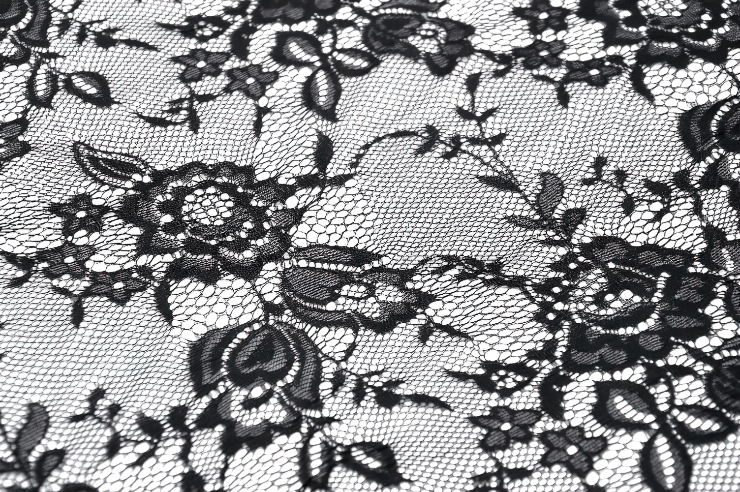 Close-up of intricate black lace fabric with floral motifs, perfect for gothic designs and elegant attire.