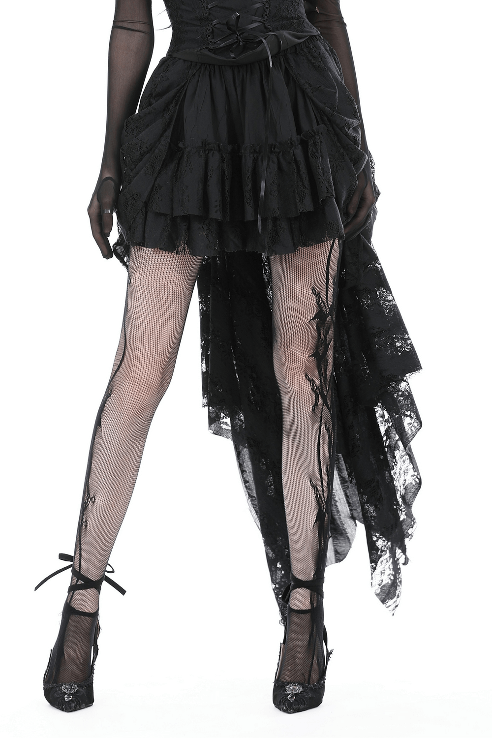 Gothic black high-low skirt with romantic ruffles and lace detail, paired with fishnet stockings and stylish heels.