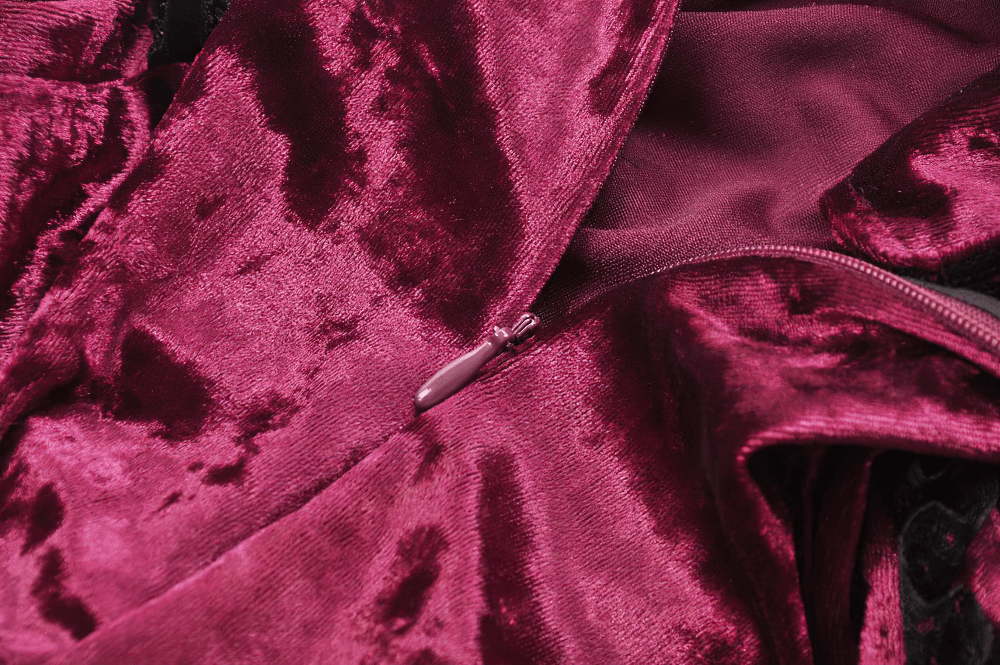 Close-up of burgundy crushed velvet fabric with a zipper, perfect for gothic and Victorian-inspired fashion.