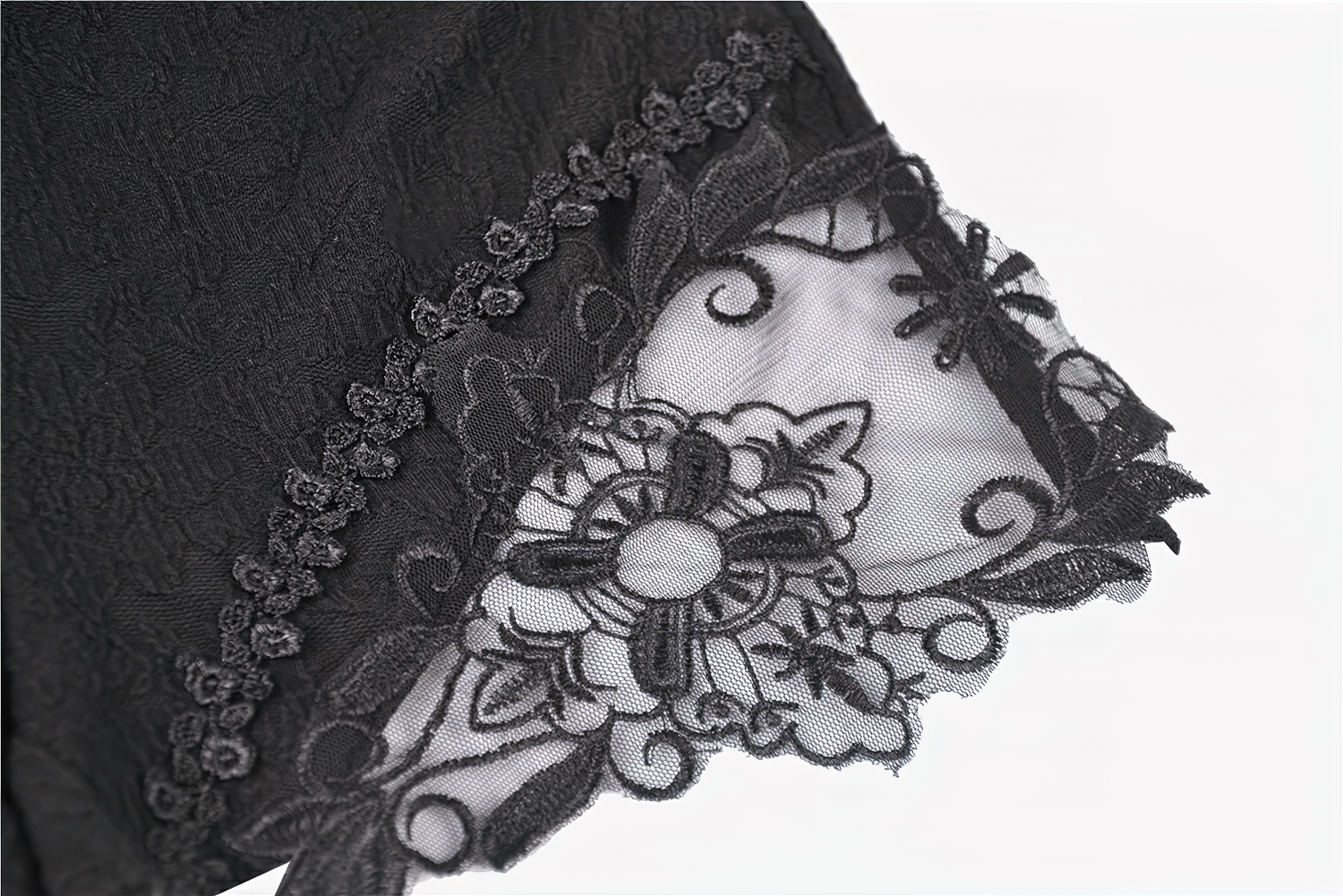 Close-up of gothic high-waist shorts with intricate lace and floral embroidery on the hem.