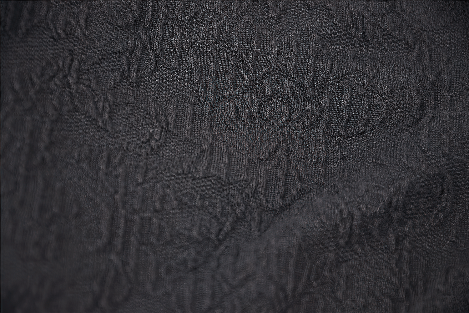 Close-up of intricate black fabric with baroque patterns, perfect for gothic fashion and elegant designs.