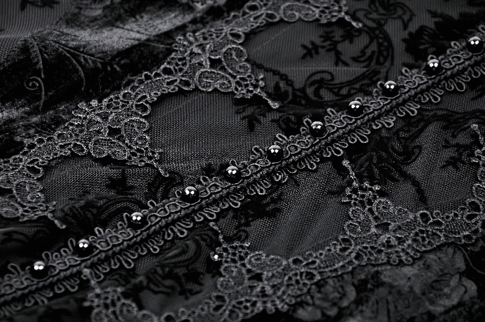 Close-up of black lace fabric showcasing intricate patterns and delicate bead detailing.