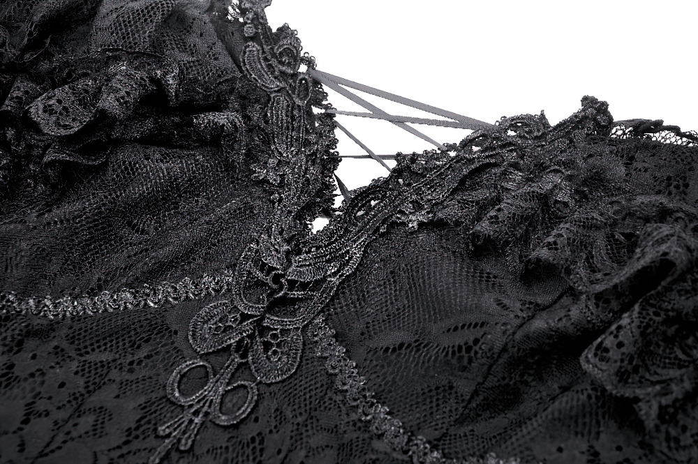 Close-up of a gothic lace black dress featuring ruffles and a corset back detail.