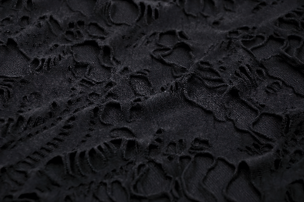 Close-up of sheer black lace fabric showcasing intricate patterns and textures, perfect for gothic fashion.