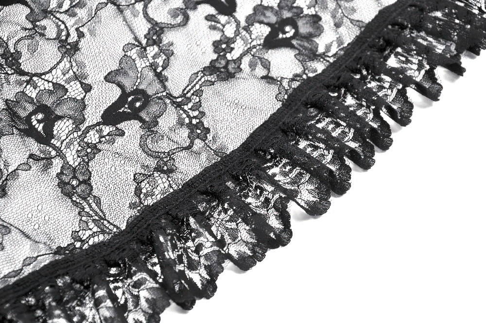 Close-up of elegant black lace fabric with intricate floral design and ruffled edges for gothic fashion.