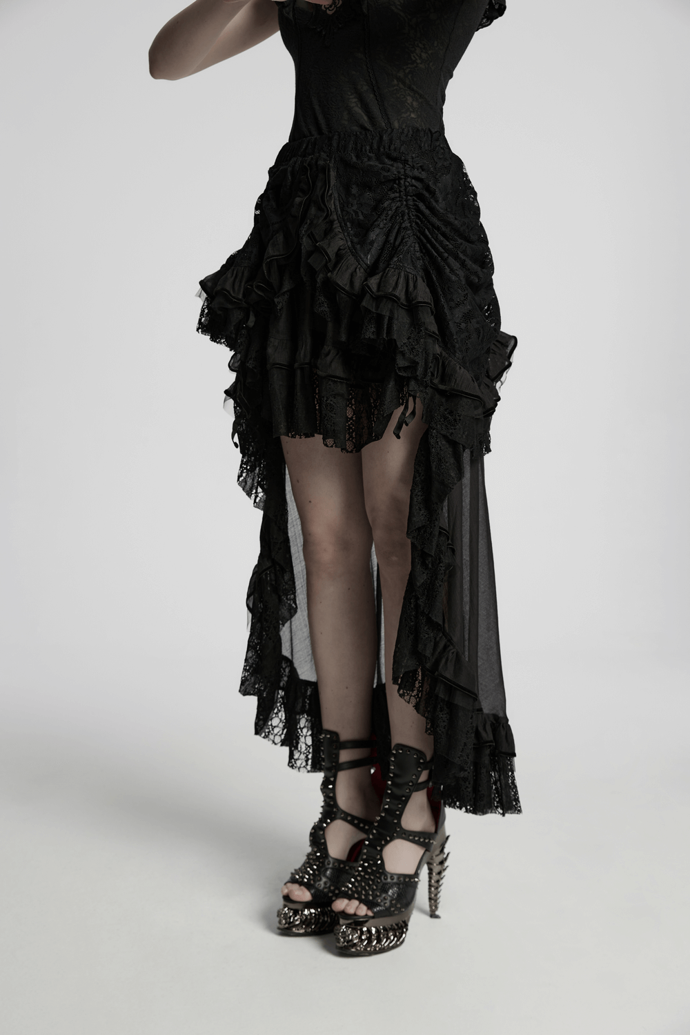 Gothic high-low lace skirt with ruffles and chiffon mesh, paired with edgy heeled shoes.