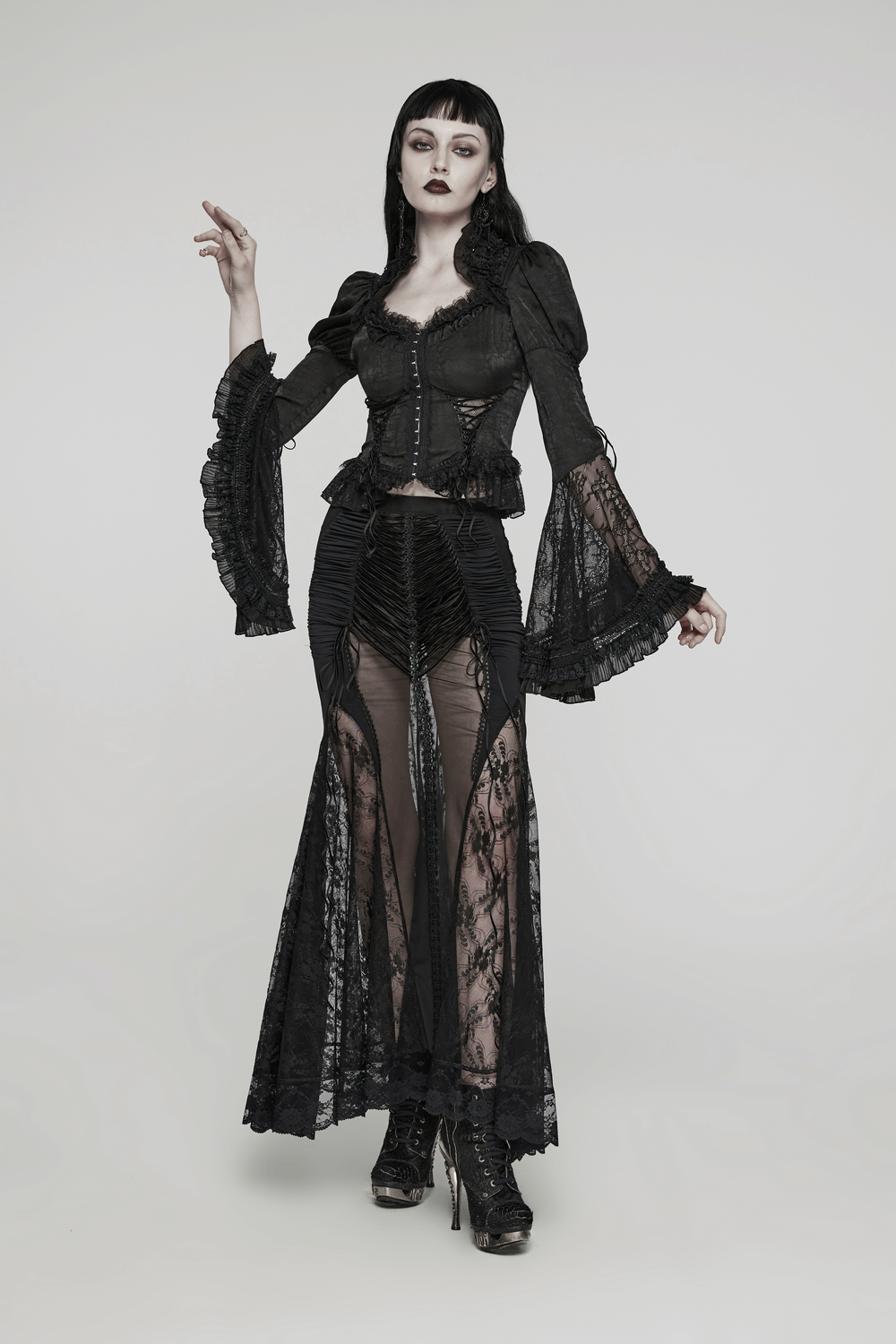 Model wearing a gothic black lace sheer long skirt and fitted top, exuding dark elegance and allure.