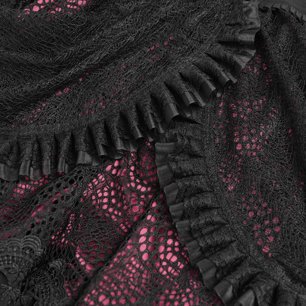 Close-up of black lace with red underlayer and ruffles, showcasing intricate design details of a gothic skirt.