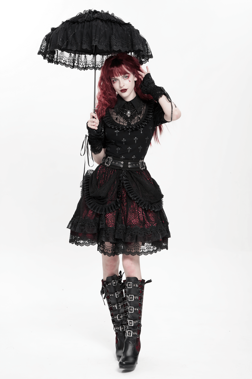Model in a gothic lace skirt with black ruffles, holding a parasol, exuding Victorian-inspired style.