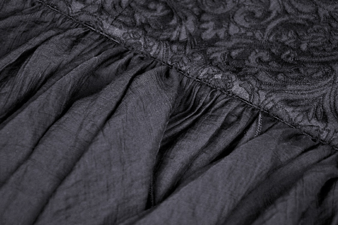 Close-up of intricate black lace fabric with elegant pleats, perfect for gothic alternative fashion.