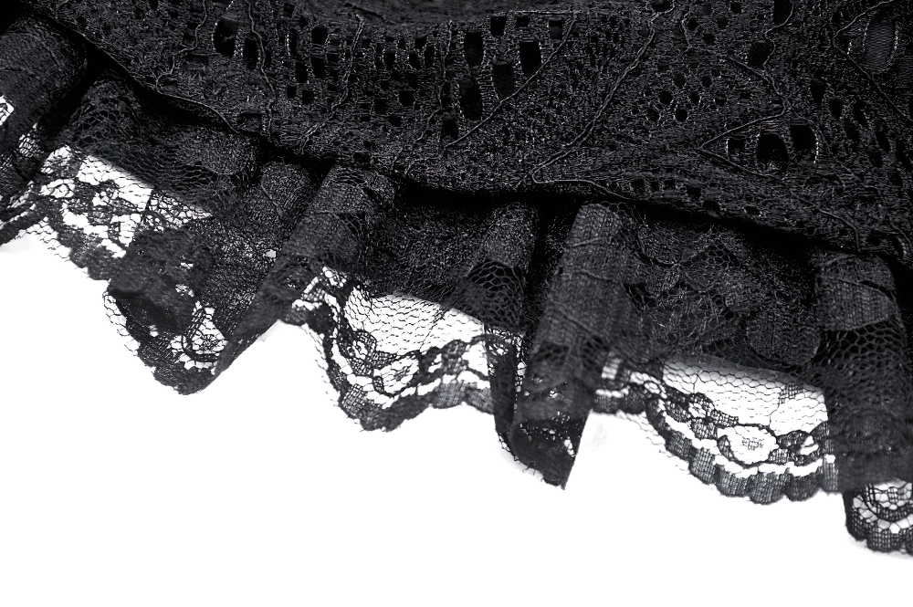 Close-up of intricate black lace hem, showcasing delicate floral patterns and texture for gothic fashion.