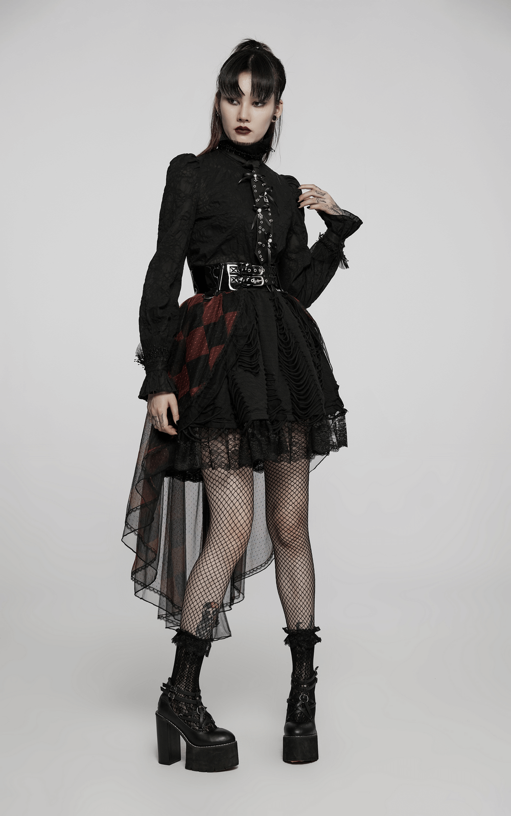 Gothic lace tie outfit with fishnet stockings and platform boots, blending punk and gothic styles in edgy fashion.