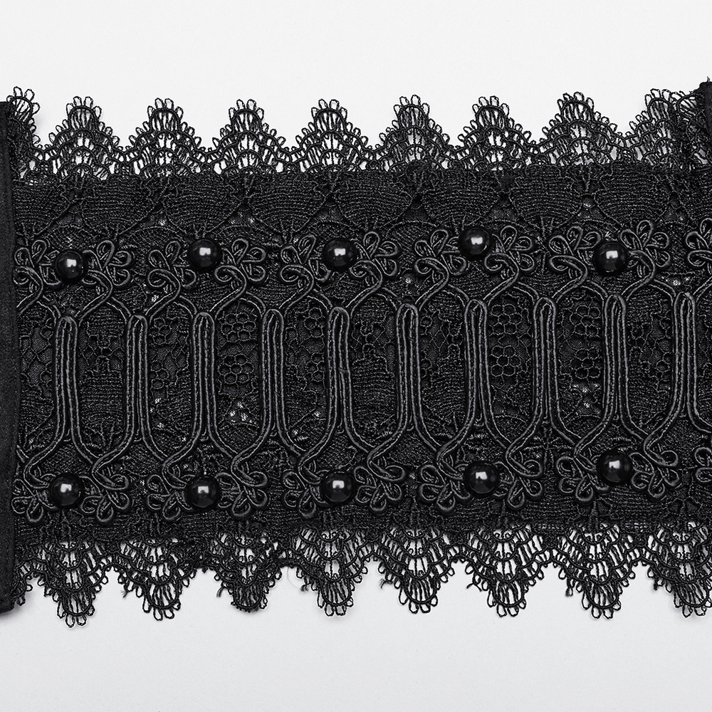 Close-up of a gothic black lace corset belt with intricate detailing and decorative beads.