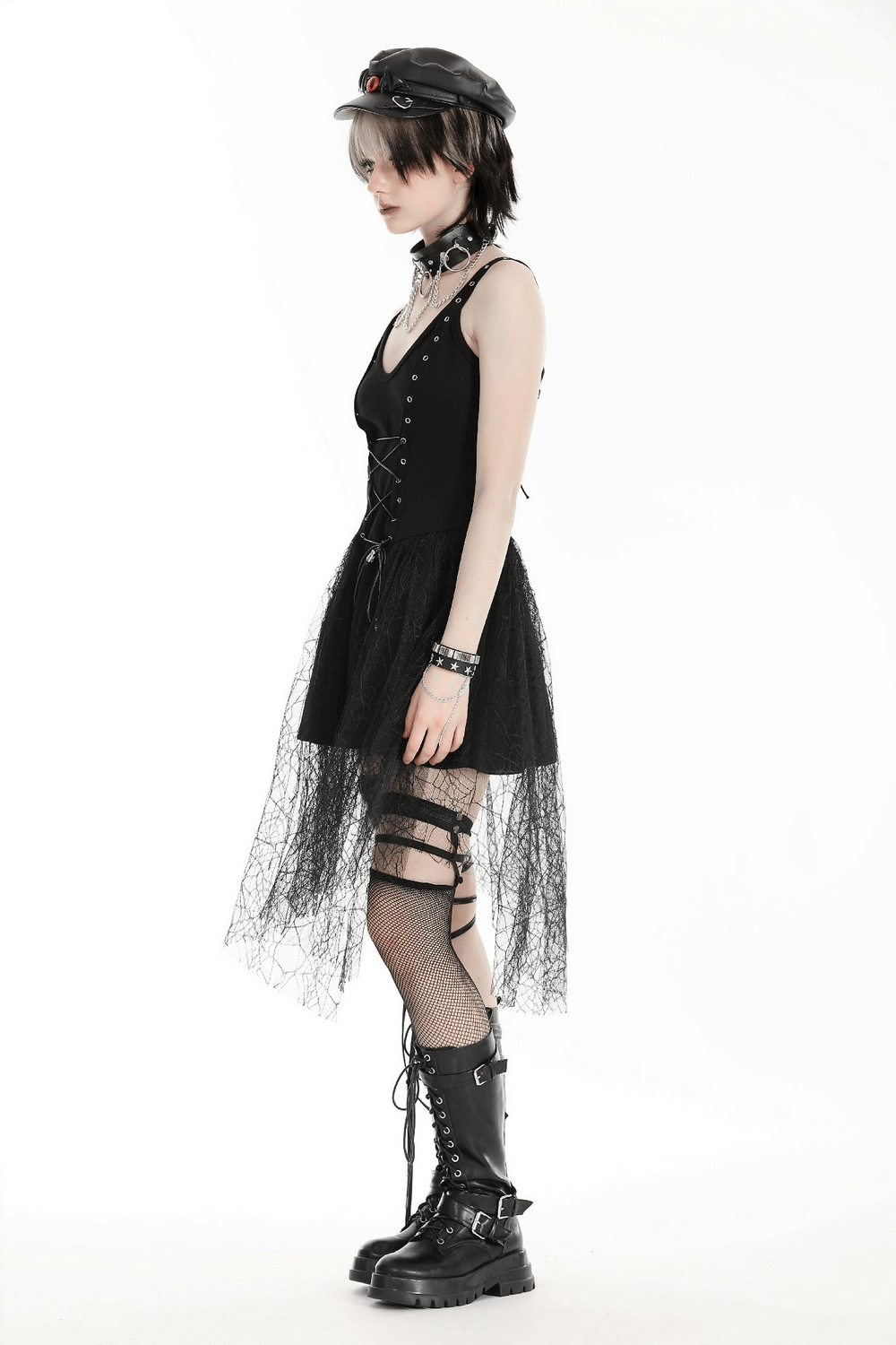 Gothic lace-up black corset dress with spider web mesh skirt, stylishly paired with platform boots and accessories.
